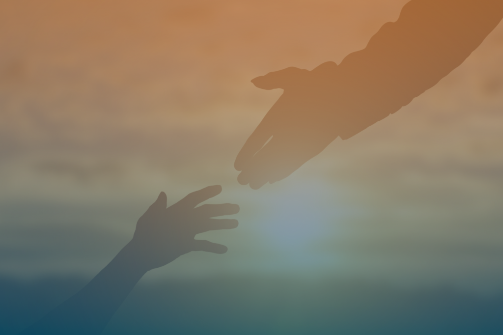 Two hands reaching for each other in front of a sunset
