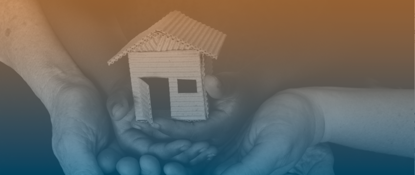 A pair of hands holding a miniature house structure
