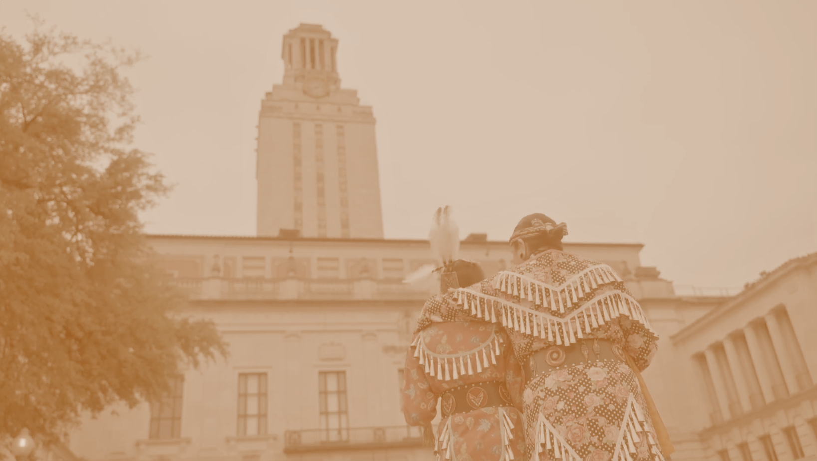 Native American standing in front of the University of Texas Tower